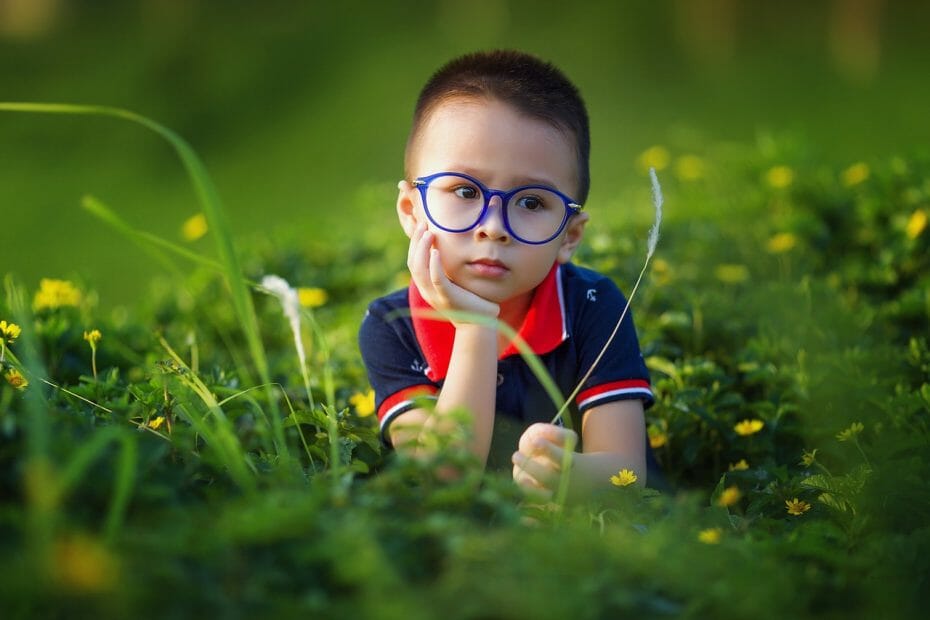 Smart child - boy with glasses in thoughtful pose