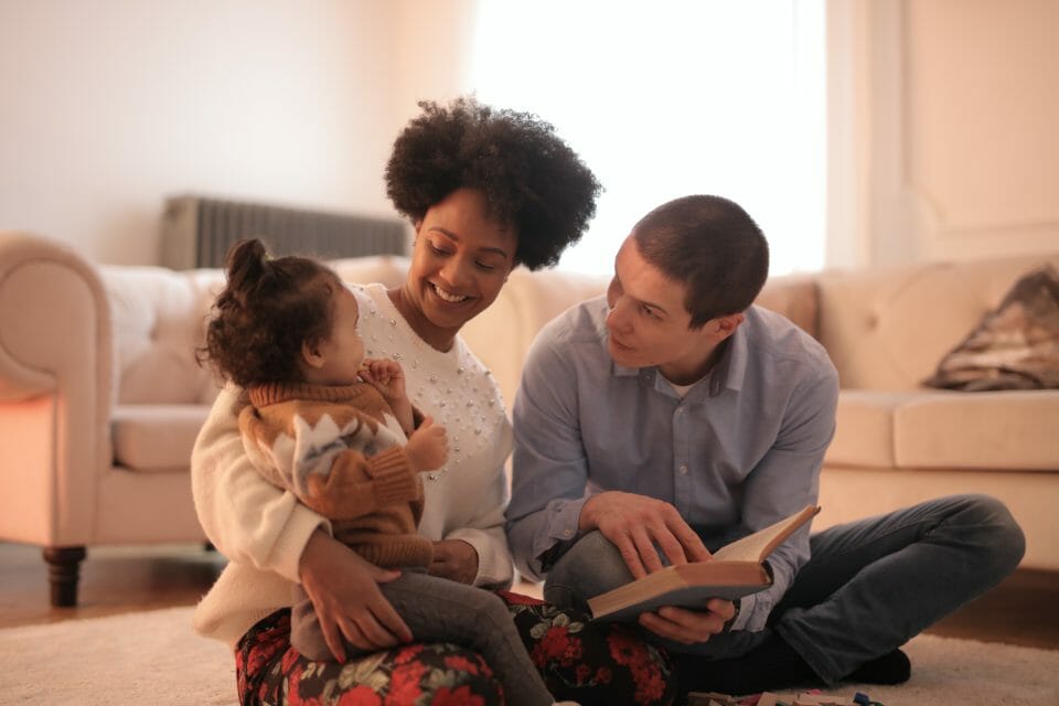 Parents reading to a little girl
